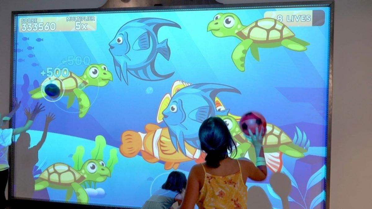 MultiBall 6 Young girl with ball play undersea them game on MultiBall exergaming multi-sports gaming wall