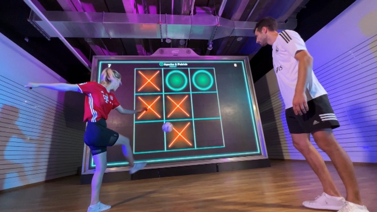 MultiBall 9 Young female kicks football onto MultiBall exergame multi-sports ball games wall