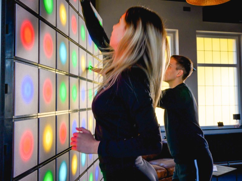 twall® 10 Young female and male compete on twall® reaction wall with LED lights for interactive sports and leisure