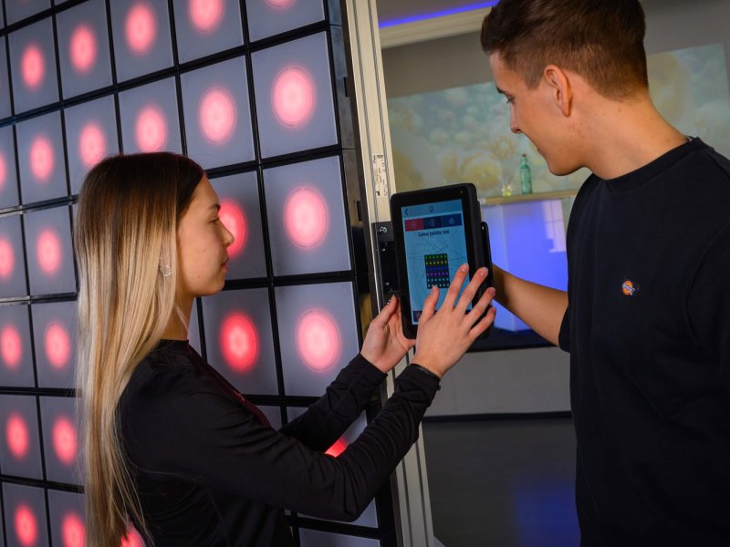 twall® 4 Young female selects game modes on twall® reaction wall with LED lights for interactive sports and leisure