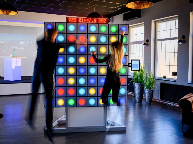 twall® 11 Young man and woman play on twall® A Series exergaming reaction wall with LED lights for interactive sports and leisure
