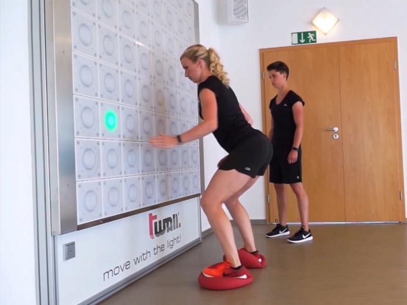 twall® 9 Young female does balance workout with twall® reaction wall with LED lights for interactive sports and leisure