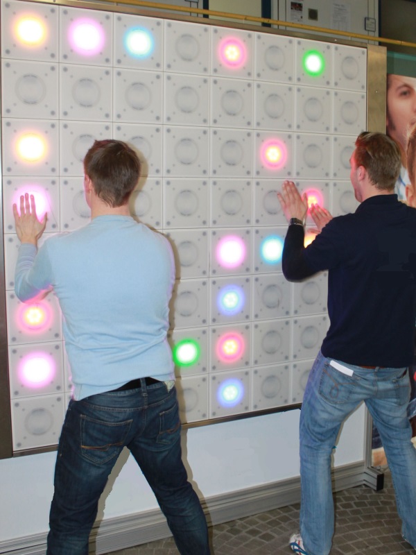 twall® 1 Two males compete on twall® A Series interactive reaction wall with 64 LED lights