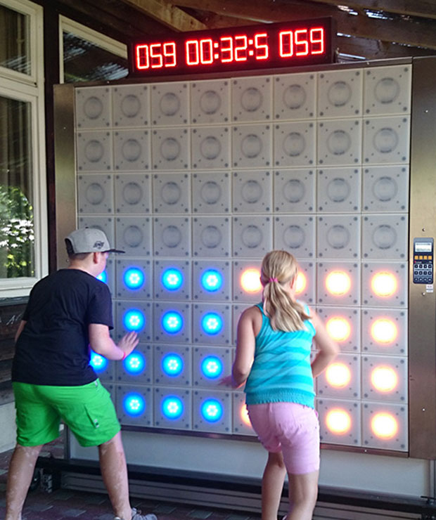 Interactive Fitness Gaming 1 Young boy and girl compete exergaming on twall® reaction wall with LED lights for interactive sports and leisure