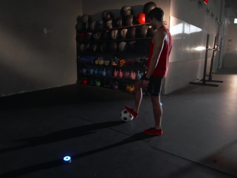BlazePod 9 Athletic male with football soccer ball and BlazePod Flash Reflex Training Lights.