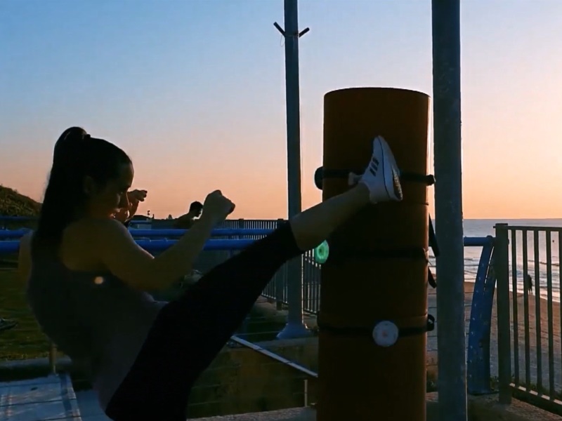 BlazePod 6 Female does interactive exercise outdoors with BlazePod Flash Reflex Training System.